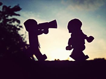 Silhouette woman standing against sky at sunset