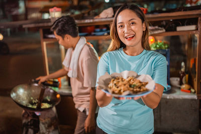 Portrait of young woman holding food