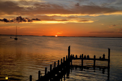 Pier on sea at sunset