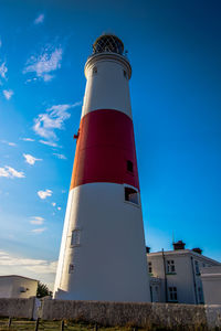 Low angle view of lighthouse by building against sky