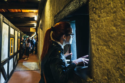 Woman looking through small window in temple