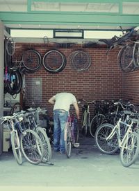 Rear view of man standing on bicycle