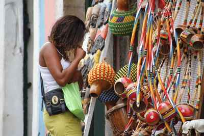 Rear view of woman standing on multi colored umbrellas