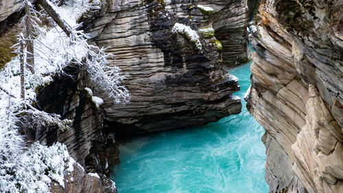 Colorful athabasca falls creek while snowing, jasper, canada.