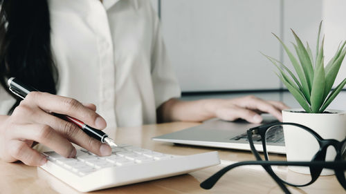 Midsection of man using mobile phone on table