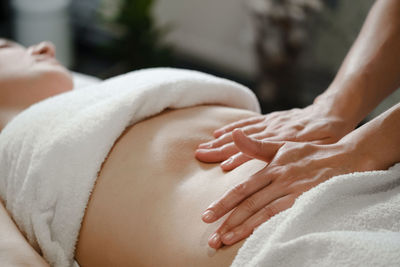 Top view of hands massaging female abdomen. therapist applying pressure on belly. woman receiving