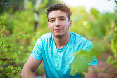 Portrait of young man holding plant