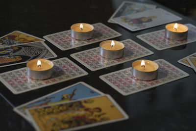 High angle view of lit candles on table