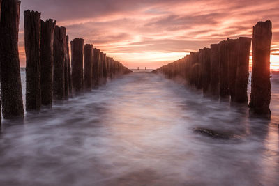 Panoramic shot of wooden post against sky during sunset