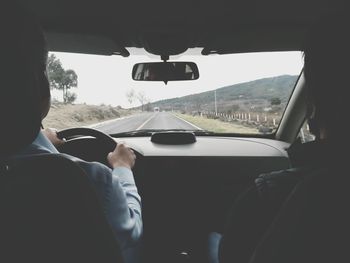 Rear view of man driving car