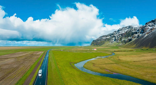 Endless road into the cloudy mountains and hills of iceland during sunny cloudy weather.