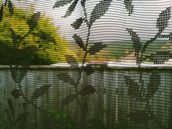 Digital composite image of tree and fence against wall