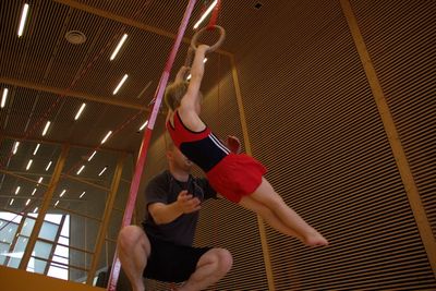 Woman with arms raised hanging on ceiling