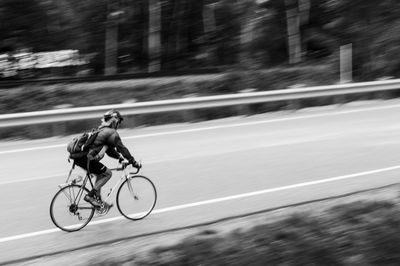 Person riding bicycle on road during sunny day