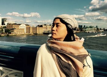 Woman standing against river and sky in city