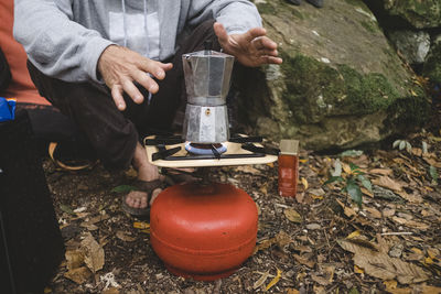Lower part of a man preparing coffee outdoors