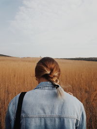 Rear view of woman standing on field