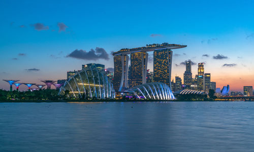 Illuminated buildings in city at waterfront