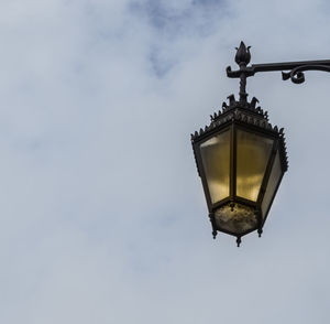 Low angle view of lamp post against cloudy sky