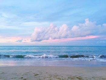 Scenic view of sea against cloudy sky during sunset