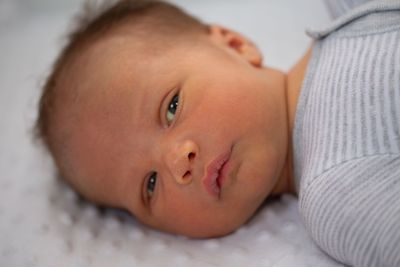 Portrait of cute baby lying on bed