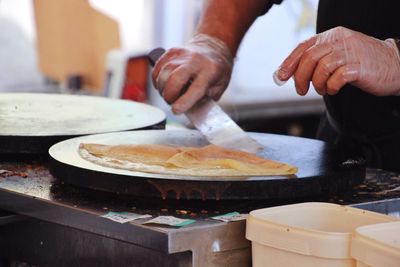 Midsection of man preparing food in kitchen