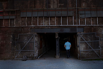 Rear view of man walking in old building