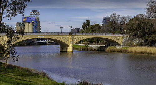 Arch bridge over river against sky