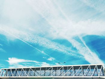 Low angle view of elevated walkway against sky