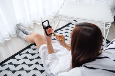 High angle view of woman relaxing on bed at home