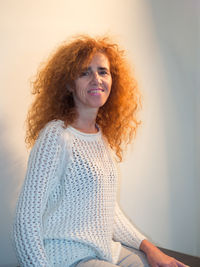 Portrait of smiling woman sitting at home