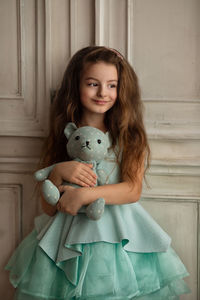 Portrait of smiling girl holding indoors