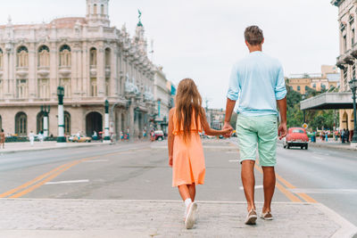 Rear view of people walking on street