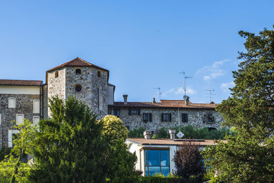 Low angle view of buildings against clear blue sky