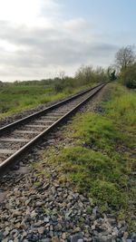 Railway tracks on landscape against sky