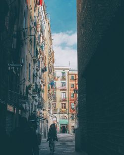 Man walking on street amidst buildings in city