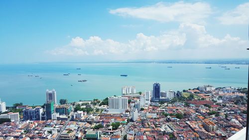 High angle view of cityscape by sea against sky