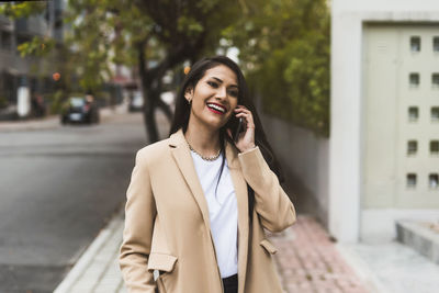 Beautiful hispanic woman taliking on the phone in the street