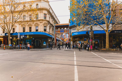 People on street amidst buildings in city