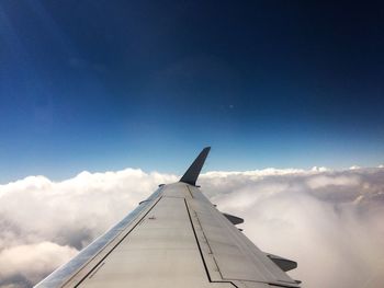 Airplane wing against cloudy sky