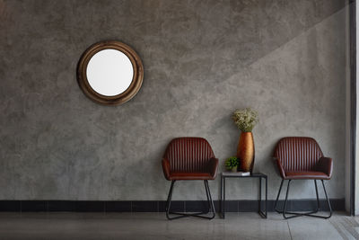 Empty chairs and table against wall at home