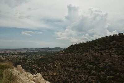 Scenic view of mountains against cloudy sky