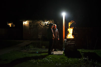 A father and son build a barbecue fire on their plot to cook dinner on an open fire. 