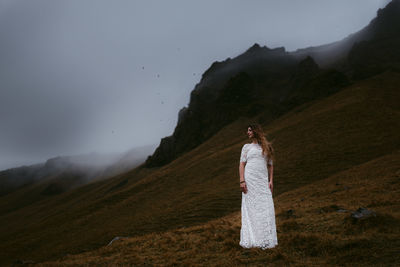 Woman standing on field against sky