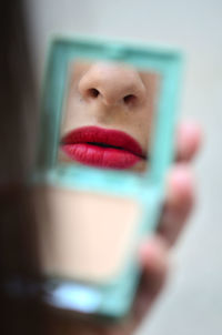 Close-up portrait of a young woman holding camera