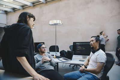 Multi-ethnic computer programmers discussing plan in creative office