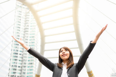 Young businesswoman gesturing while standing in city