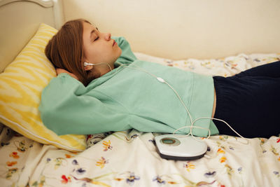 Portrait of young woman lying on bed at home