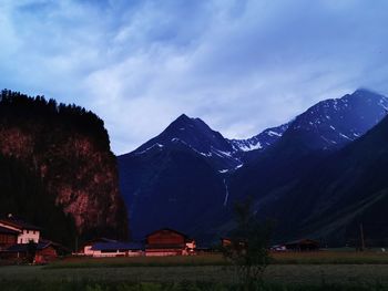 Houses by mountains against sky