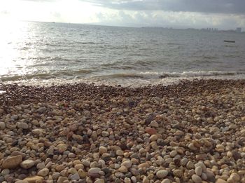 Scenic view of beach against cloudy sky